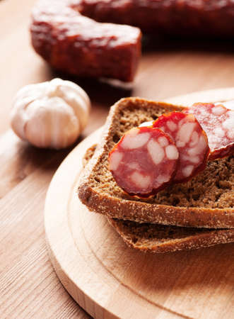 Rye bread sandwich with sausage, salami and garlicの写真素材