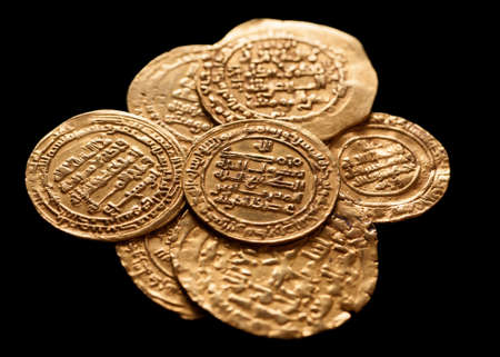 Ansient golden islamic coins isolated on black, closeup, selective focusの写真素材