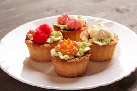 Four colorful cake basket on a white plateの写真素材