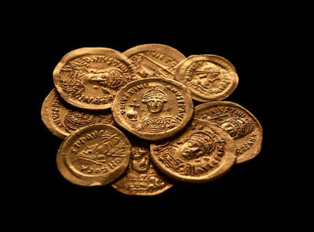 Pile of ancient golden Byzantine coins isolated on black, selective focus, closeupの写真素材