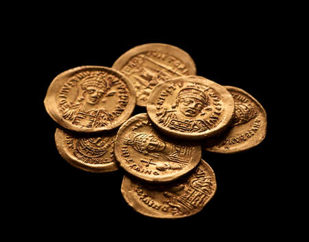 Pile of ancient golden Byzantine coins isolated on black, selective focus, closeupの写真素材