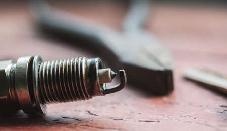 Spark plug with tools on a wooden table, closeupの写真素材