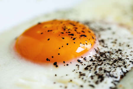 Fried egg with black pepper, macro shotの写真素材