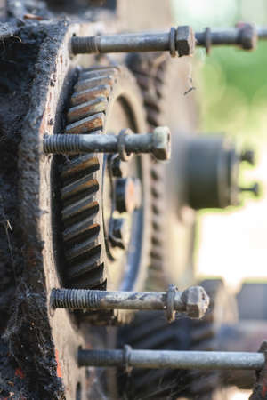 Dirty gear with bolts, selective focus, vertical