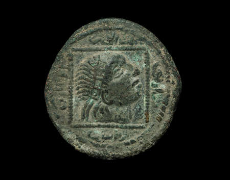 Islamic ancient bronze coin isolated on black, close-up shotの写真素材