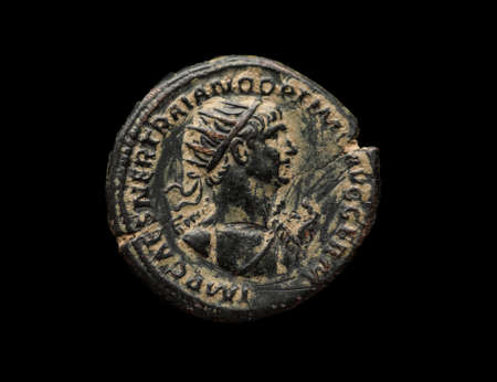 Ancient roman bronze coin of Trajan emperor isolated on black, close-up shotの写真素材