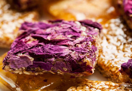 Pile of oriental sweets with nuts, seeds and rose petals, macro shot, selective focusの写真素材