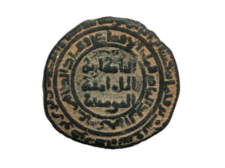 Ancient round islamic copper coin with arabic letters isolated on white, macro shotの写真素材