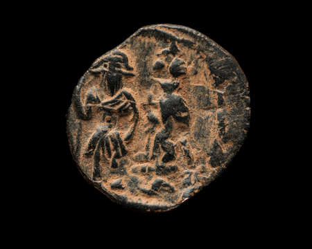 Ancient copper Byzantine coin isolated on black, close-up shotの写真素材