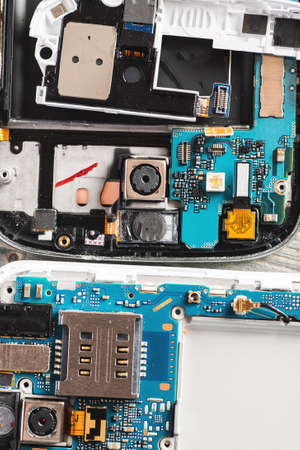 Disassembled gadgets modules on a wooden table, overhead view, selective focusの写真素材
