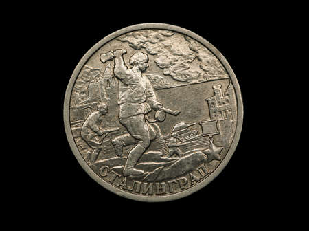 Russian commemorative coin with city of military glory Stalingrad with images of defenders on it isolated on black, macro shotの写真素材