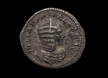 Ancient roman silver coin with female portrait isolated on black, macro shotの写真素材