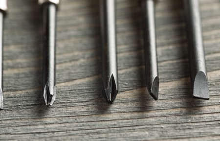 Black metal screw drivers on wooden table, macro shot, selective focusの写真素材