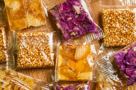 Close-up shot of oriental sweets in plastic package on wooden table, selective focus, overhead viewの写真素材