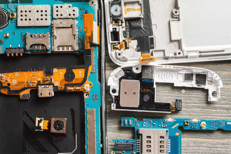 Parts of disassembled digital gadgets on wooden table, selective focus, overhead viewの写真素材
