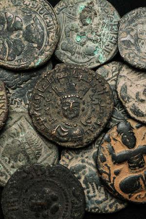 Pile of ancient islamic bronze coins close-up shot, selective focus, verticalの写真素材