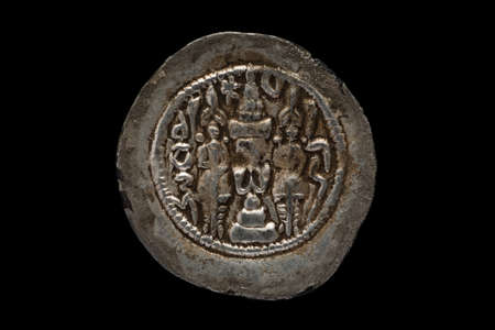 Ancient round silver coin close-up shot, isolated on blackの写真素材