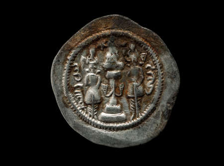 Ancient silver Sassanian coin isolated on black, close-up macro shotの写真素材