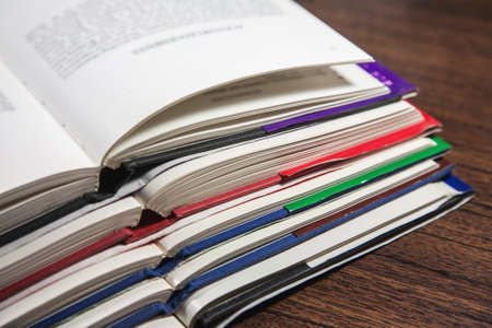 Stack of open books on wooden table, closeup shotの写真素材