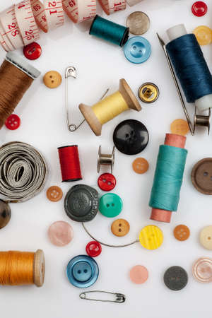 Threads, needles, buttons and other sewing stuff on a white background, flat lay composition, top view, vertical.の写真素材