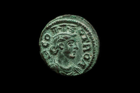 Antique roman provincial copper coin isolated on black, close-up shot