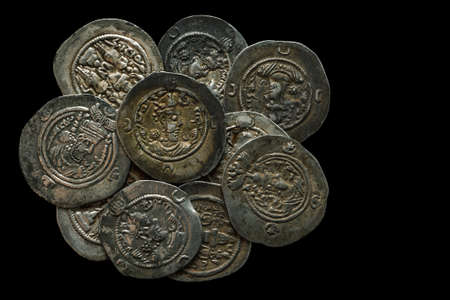 Pile of ancient silver coins isolated on black, selective focusの写真素材