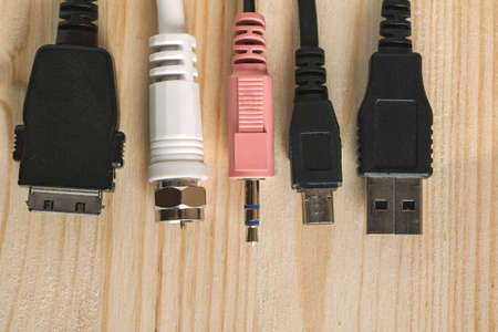 Connectors of various digital interfaces on wooden table, overhead view, selective focusの写真素材