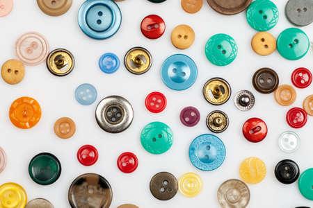 Close-up shot of many different buttons on a white background, flat lay patternの写真素材