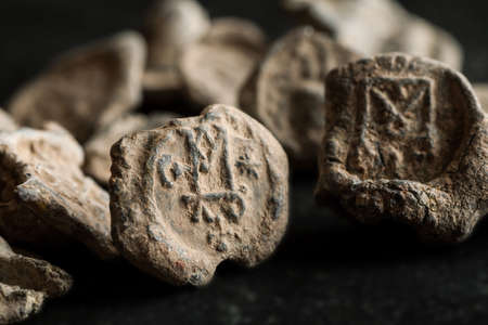 Antique post seals made of lead with monograms, black background, close-up shot, front viewの写真素材