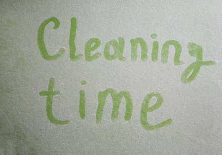 Handwritten cleaning time on dusty surface, selective focusの写真素材