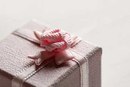 Closeup shot of pink gift box with small bow on the top.