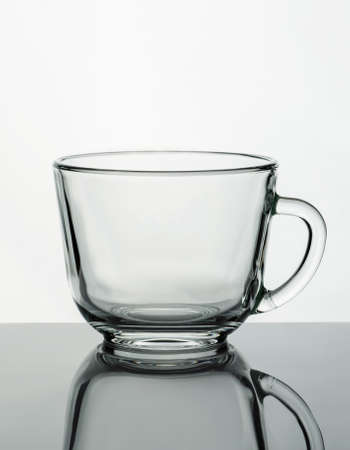 Empty glass mug on a reflective surface. Product photography.の写真素材