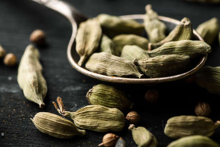 Cardamon dry seeds in a metal spoon closeup macro shot.の写真素材
