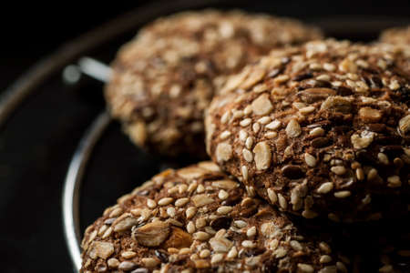 Homemade oatmeal cookies with nuts and seeds on a metal stand with other stuff, closeup shot.