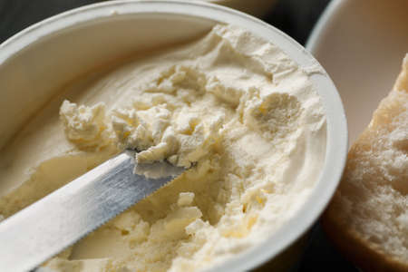 Cream cheese in plastic jar macro shot.の写真素材