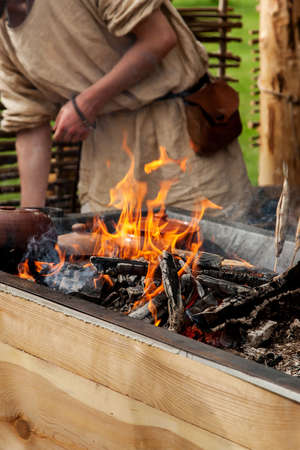 Flame of fire and pots with food in it, open fire cooking, vertical.の写真素材