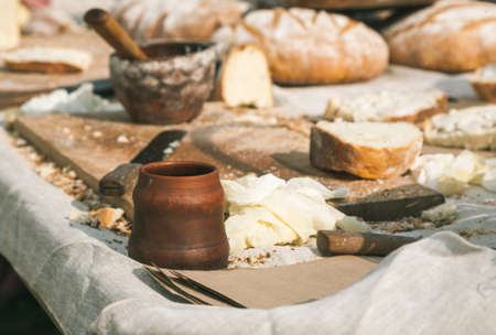 Table full of bread and some dishes on it, outdoors soft sun light.の写真素材
