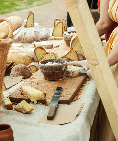 Sliced bread on a wooden table and person making sandwiches, vertical.の写真素材