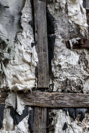 Old wooden door with shabby insulation, selective focus, verticalの写真素材