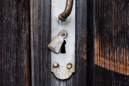 Vintage white metalic handle on an old wooden door, selective focusの写真素材
