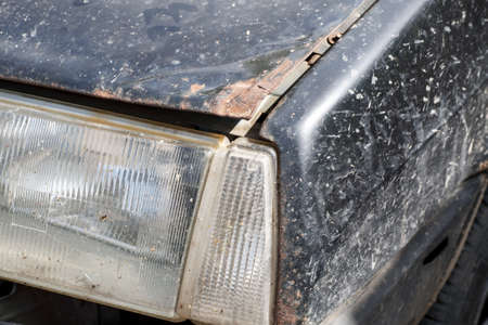 Headlight of an old car with rusted hoodの写真素材