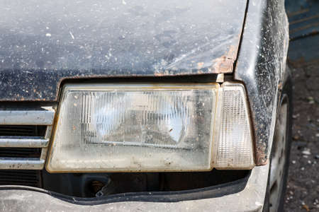Headlight of an old car with rusted hood, closeup shotの写真素材