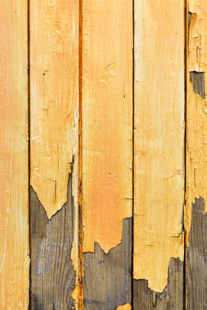 Wooden planks with peeled yellow paint, abstract texture, verticalの写真素材