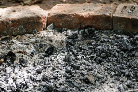 Burned place after fire with ashes and bricks around