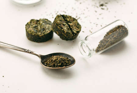 Different dry green tea on a white background