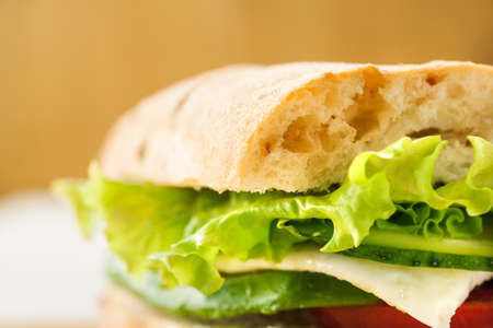 Vegetarian sandwich with avocado, tomato, egg and green salad on a wooden board, macro shot