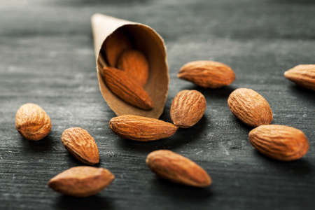 Paper cone bag with almond on a black wooden boardの写真素材