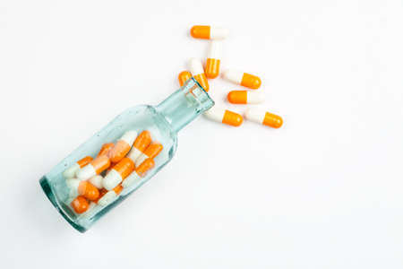 Different medications and pills with vintage pharmacy bottles on a white background