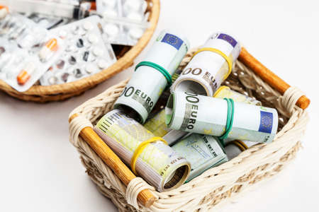 Different medications and pills with euro banknotes on a white background