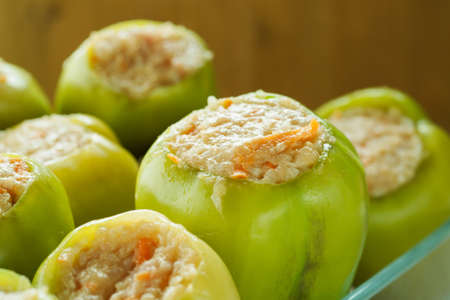 Fresh green bell peppers stuffed with meat with rice in a glass dishの写真素材